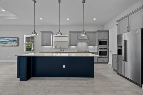 a kitchen with stainless steel appliances granite countertop a refrigerator a sink and a stove