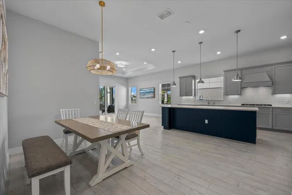a room with a table chairs and a kitchen view