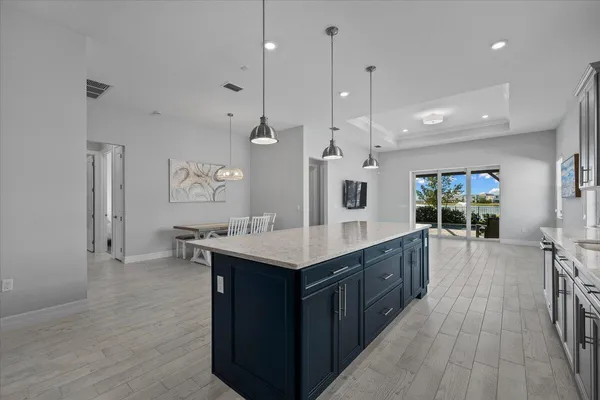 a kitchen with stainless steel appliances kitchen island a large island in the center and wooden floors