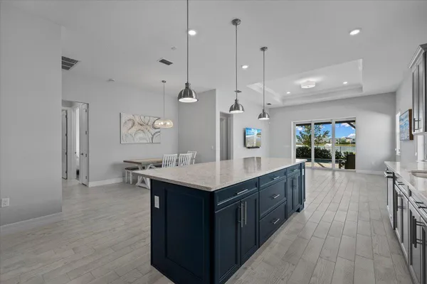 a kitchen with stainless steel appliances kitchen island a large island in the center and wooden floors