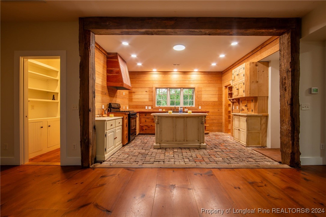 222 Goodwill Road Southern Pines, NC 28387 - Photo 12 of 49 a view of a kitchen with kitchen island a window wooden floor and stainless steel appliances