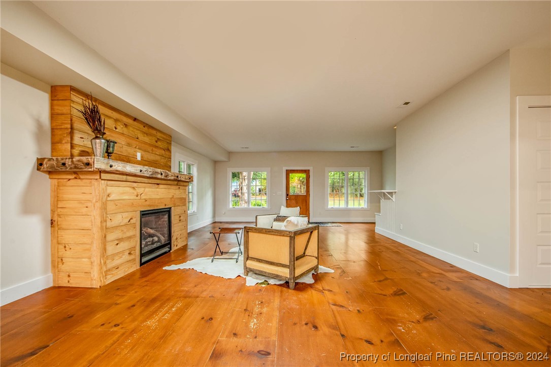222 Goodwill Road Southern Pines, NC 28387 - Photo 16 of 49 a view of a livingroom with furniture a fireplace and wooden floor