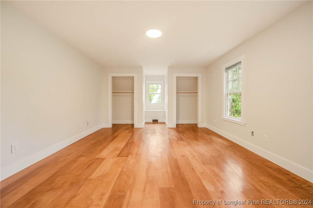 222 Goodwill Road Southern Pines, NC 28387 - Photo 28 of 49 an empty room with wooden floor and windows