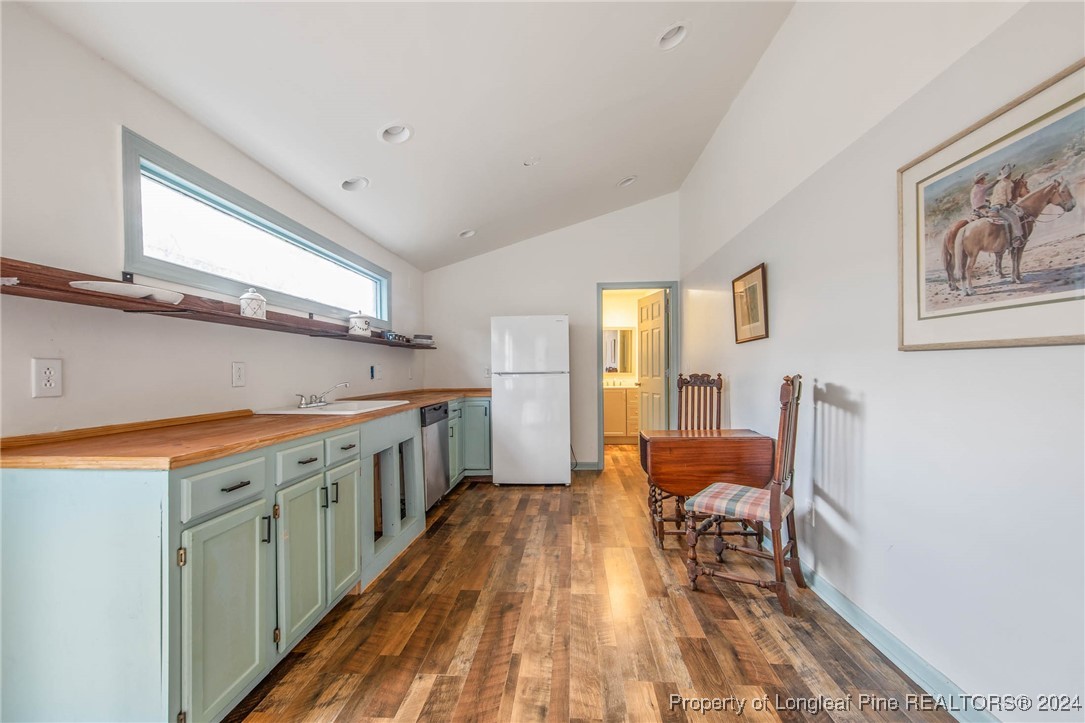 222 Goodwill Road Southern Pines, NC 28387 - Photo 49 of 49 a kitchen with stainless steel appliances granite countertop a stove a sink a refrigerator white cabinets and wooden floor