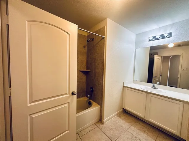 a bathroom with a tub a sink a mirror and a shower