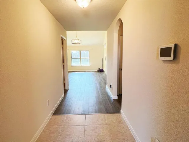 a view of a hallway with wooden floor and a bathroom