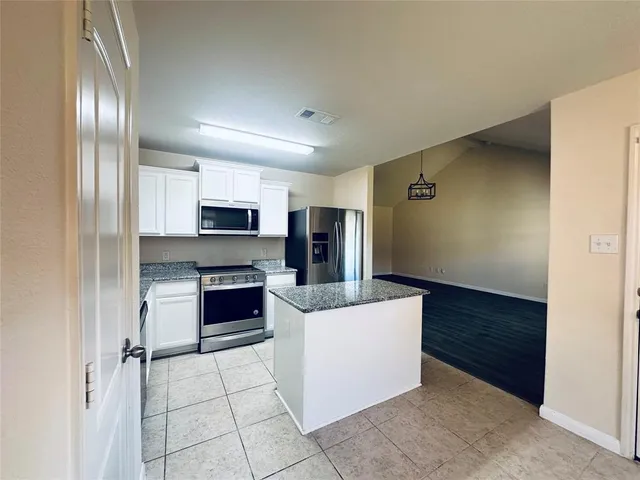 a kitchen with stainless steel appliances a refrigerator and a stove top oven
