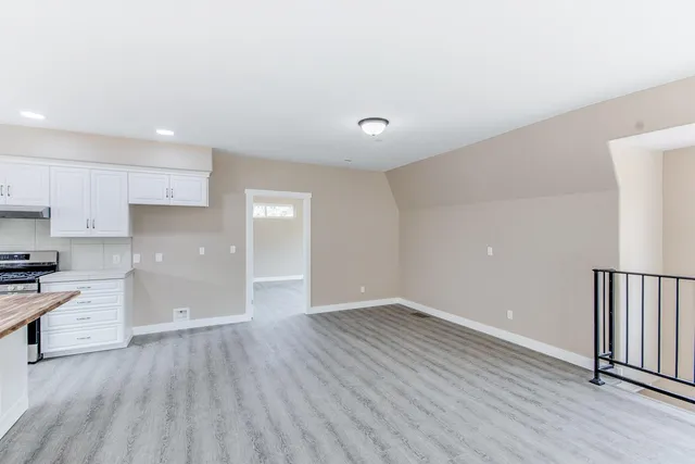 a view of a kitchen with wooden floor and electronic appliances