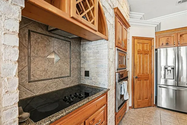 a kitchen with stainless steel appliances granite countertop a refrigerator a stove and a sink with wooden floor