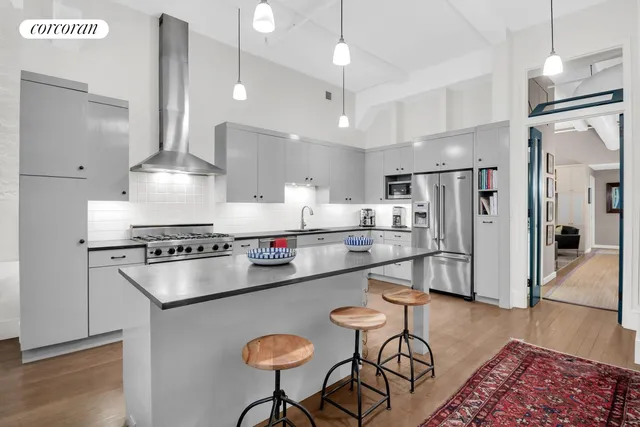 a kitchen with stainless steel appliances granite countertop a refrigerator a stove a sink dishwasher a refrigerator and white cabinets with wooden floor