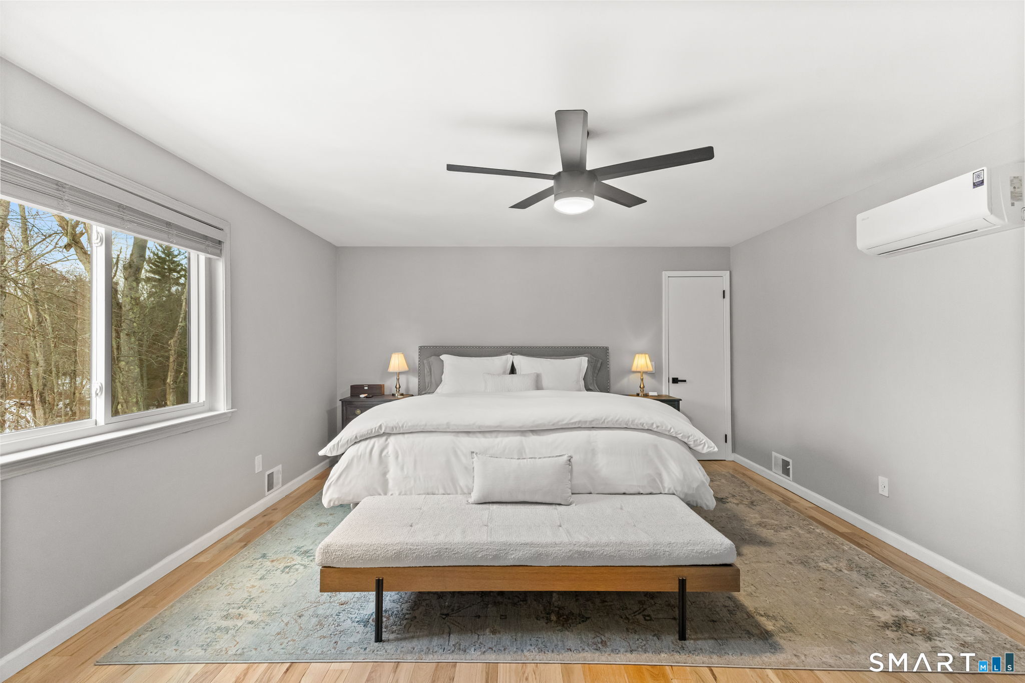 299 Redding Road Redding, CT 06896 - Photo 17 of 40 a spacious bedroom with a bed chandelier and a window