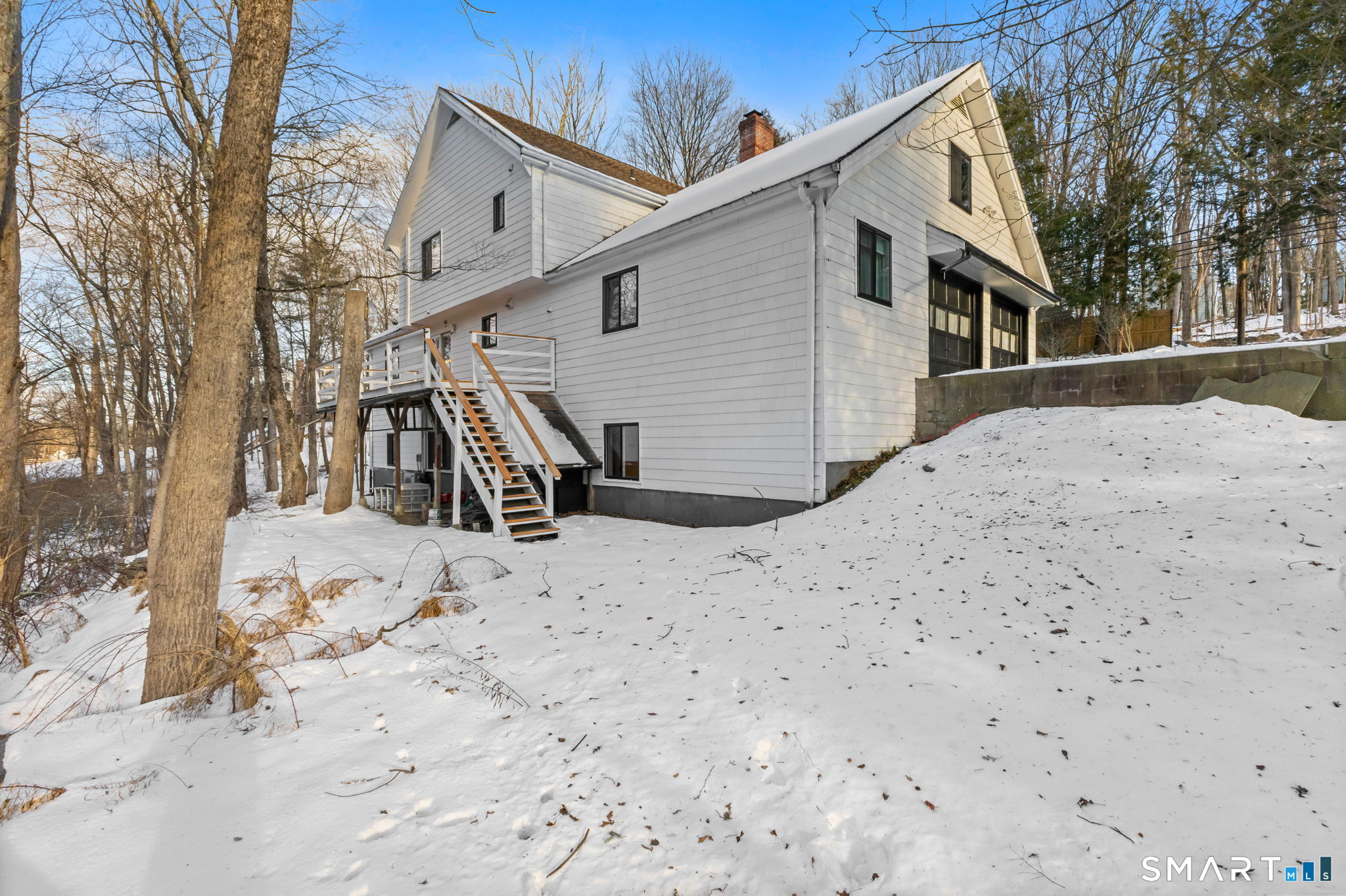 299 Redding Road Redding, CT 06896 - Photo 35 of 40 a view of a white house with a snow on the road