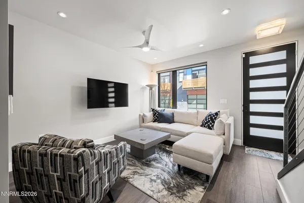 a living room with furniture a flat screen tv and windows