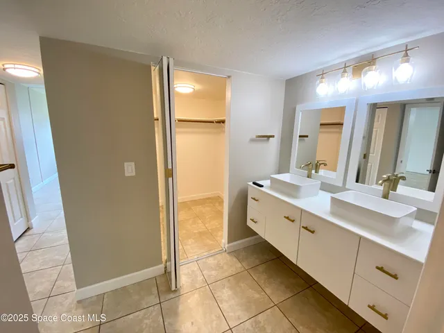 a bathroom with a double vanity sink a mirror and a shower