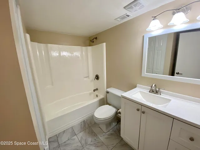 a bathroom with a sink a toilet a mirror a vanity and shower