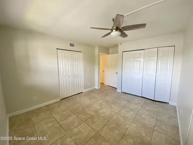 an empty room with fan and windows