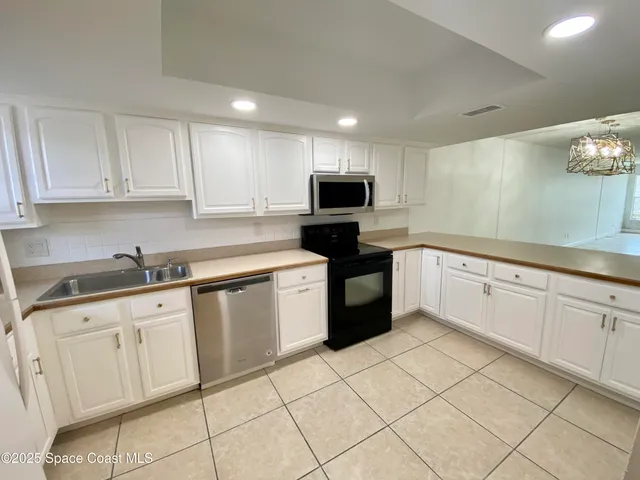 a kitchen with white cabinets a sink and white appliances