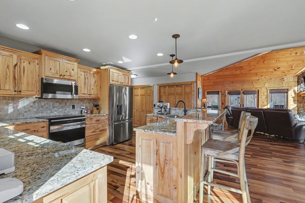 4760 Anderson Road Hiawassee, GA 30546 - Photo 28 of 104 a large kitchen with kitchen island a large counter top space appliances and cabinets