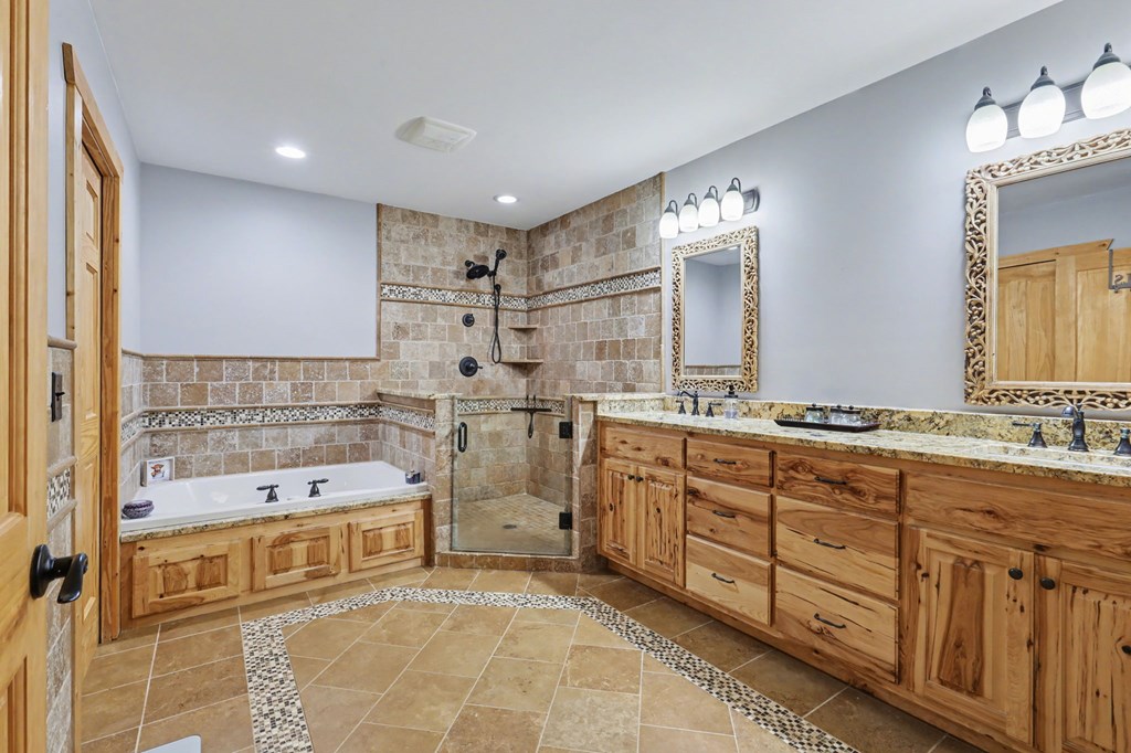 4760 Anderson Road Hiawassee, GA 30546 - Photo 35 of 104 a spacious bathroom with a double vanity sink a mirror and a bathtub