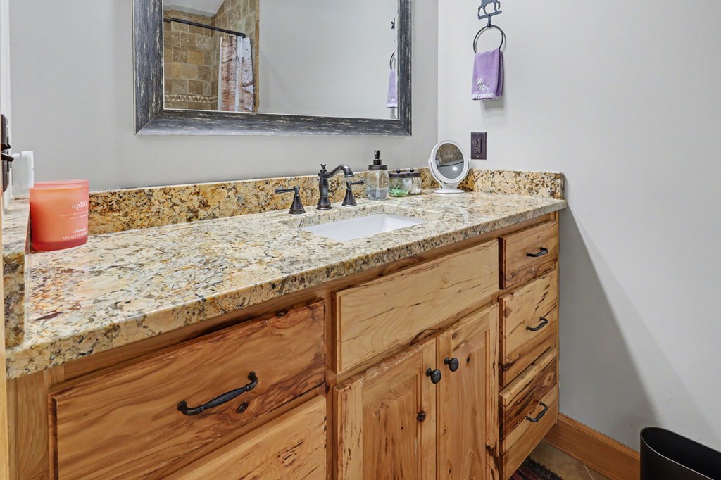 4760 Anderson Road Hiawassee, GA 30546 - Photo 54 of 104 a bathroom with a granite countertop sink and a mirror