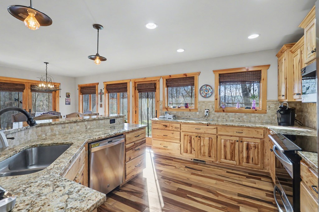 4760 Anderson Road Hiawassee, GA 30546 - Photo 9 of 104 a large kitchen with granite countertop a sink and a stove top oven with wooden floor
