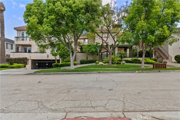 a front view of a house with a garden and trees