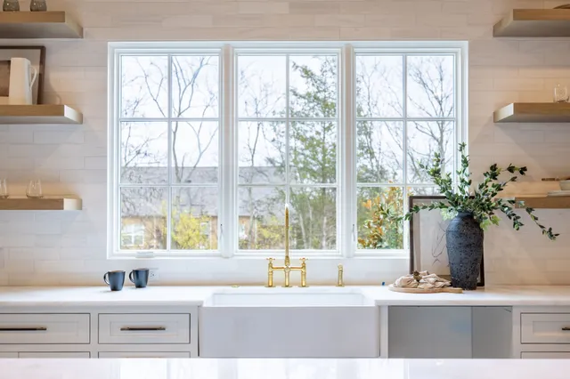 a vase of flowers sitting on a table with window