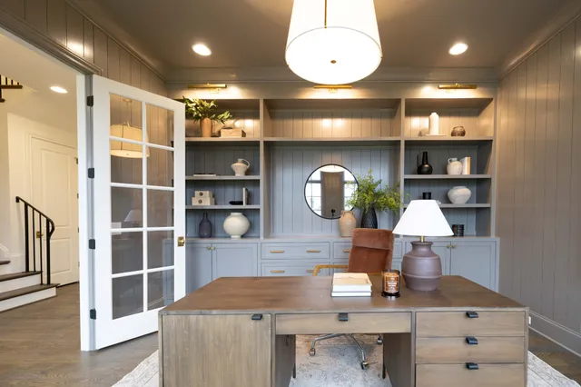 an empty room with windows and ceiling fan