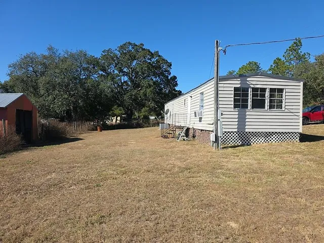 a view of a house with a yard and potted plants