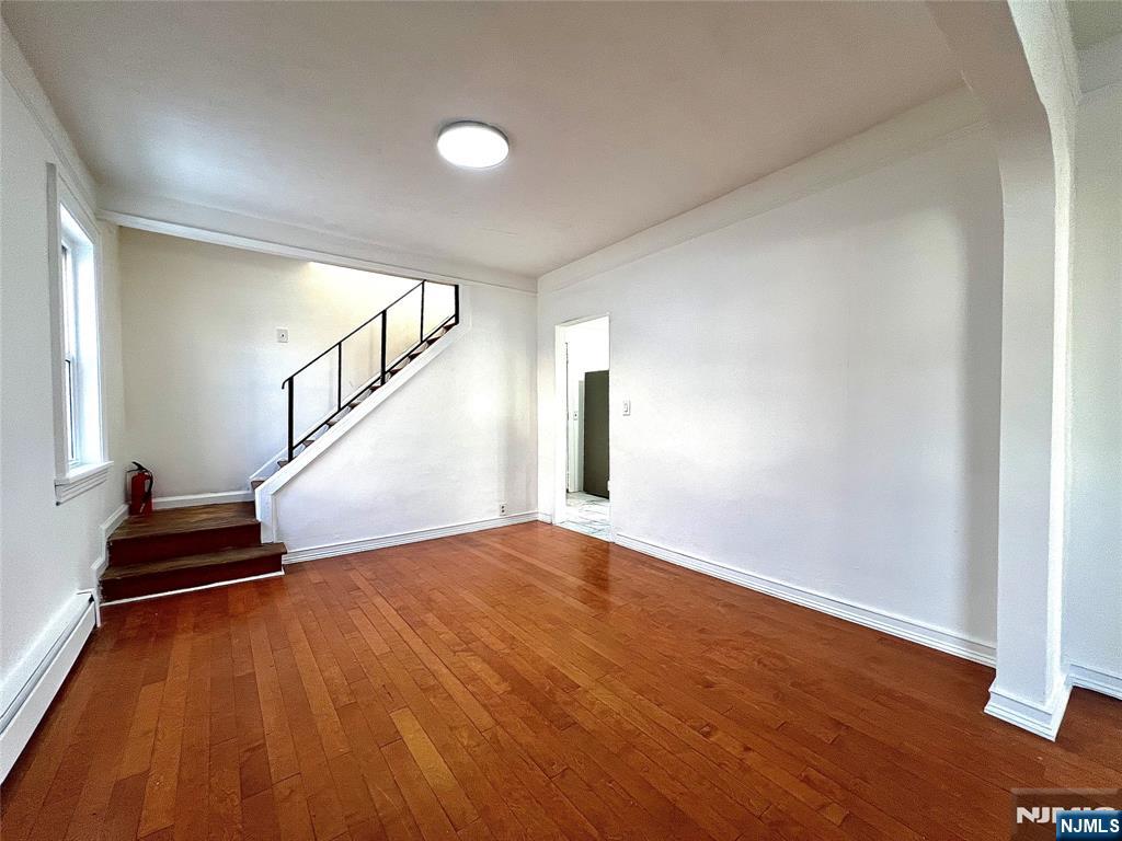 a view of empty room with wooden floor