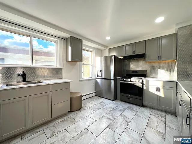 a kitchen with granite countertop a refrigerator and a sink