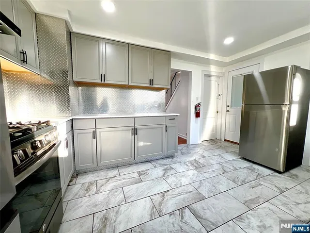 a kitchen with a refrigerator and a stove top oven