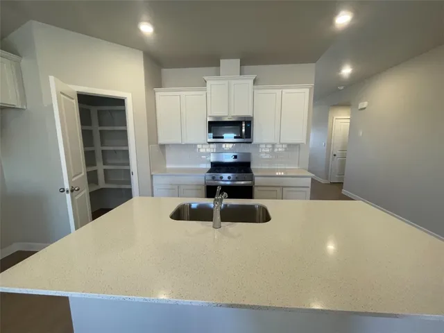 an empty room with chandelier fan and windows