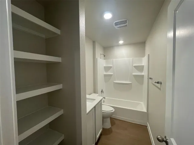 a bathroom with a granite countertop toilet sink and mirror