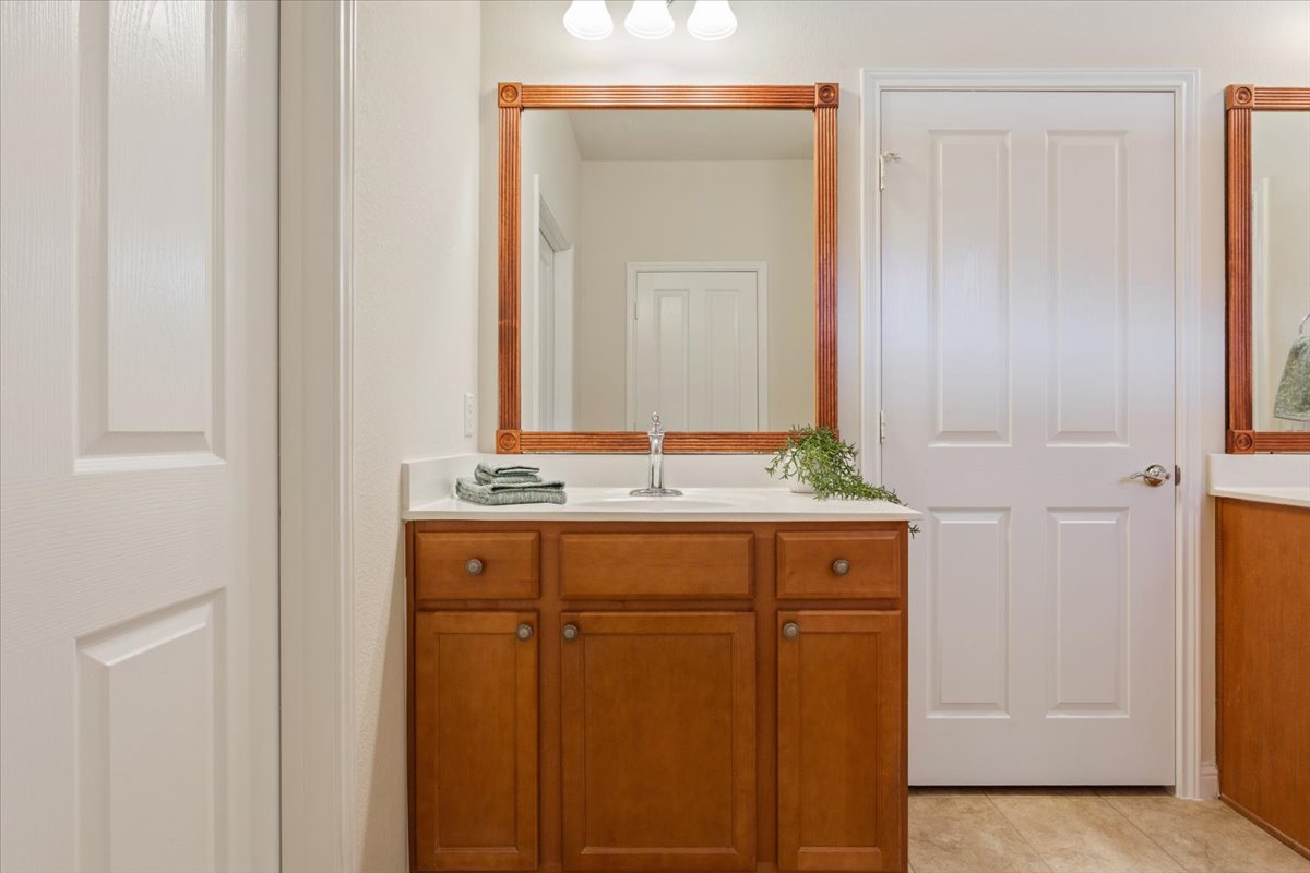108 Cathedral Mountain Pass Georgetown, TX 78633 - Photo 22 of 36 a bathroom with a granite countertop sink and a mirror