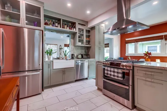 a kitchen with counter top a potted plant and cabinets