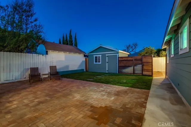 a backyard of a house with table and chairs