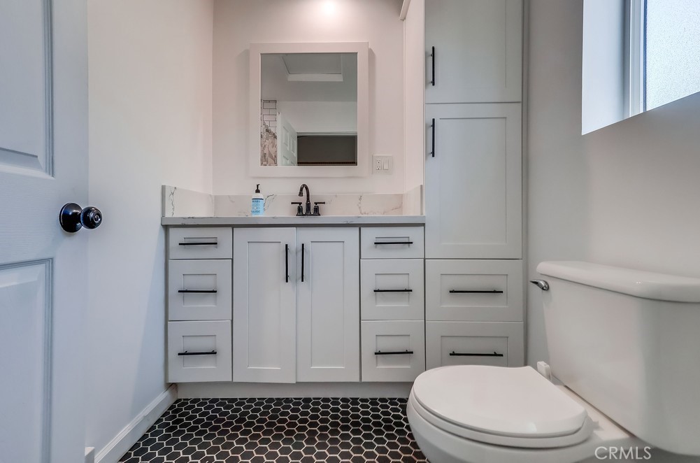 456 Cherry Avenue Long Beach, CA 90802 - Photo 71 of 74 a bathroom with a granite countertop toilet sink and mirror