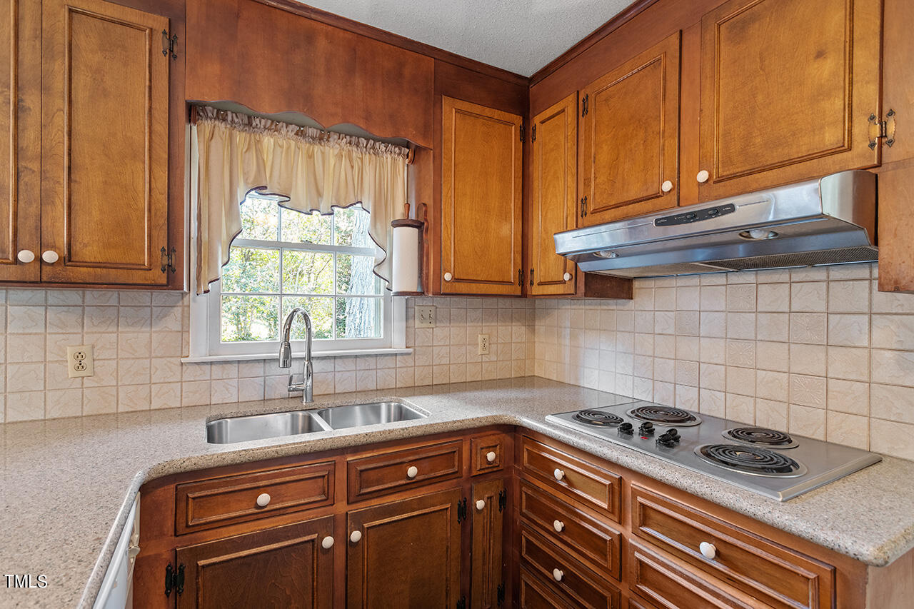 2900 New Hope Church Road Raleigh, NC 27604 - Photo 22 of 34 a kitchen with a stove a sink and cabinets