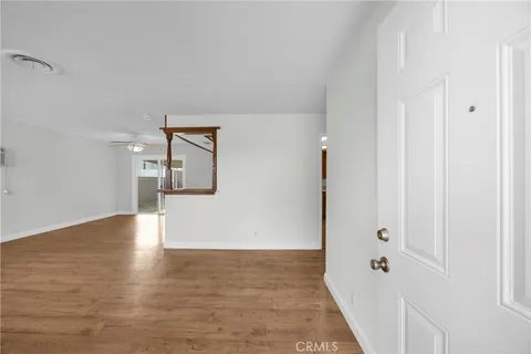 a view of a hallway with wooden floor and cabinet