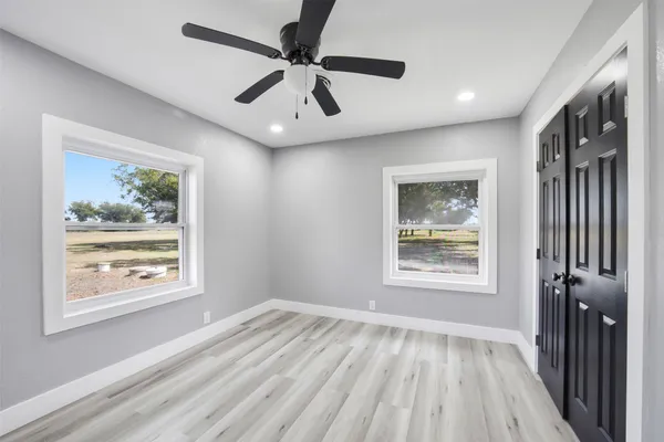 a view of an empty room with a window and wooden floor