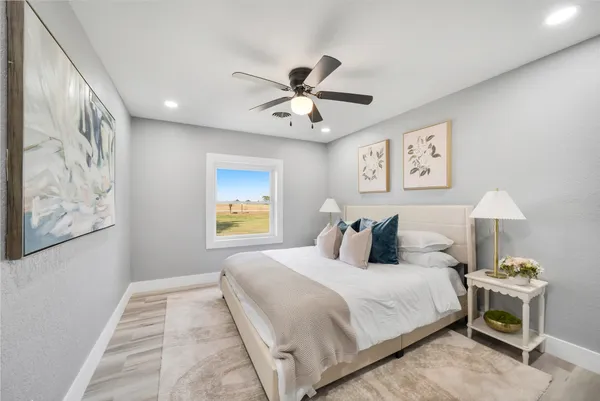 a bedroom with a bed and a painting on the wall