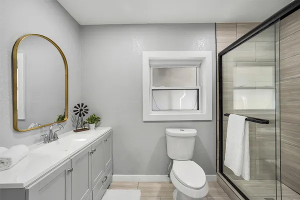 a bathroom with a toilet a sink and mirror