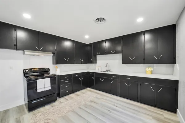 a large kitchen with granite countertop a stove and a sink
