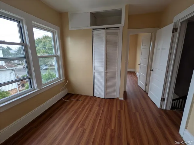 a view of hallway with wooden floor and window