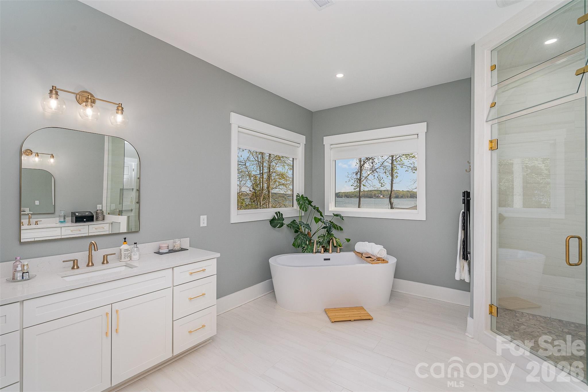 5056 Bridge Way Denver, NC 28037 - Photo 21 of 42 a spacious bathroom with a double vanity sink a mirror and a bathtub
