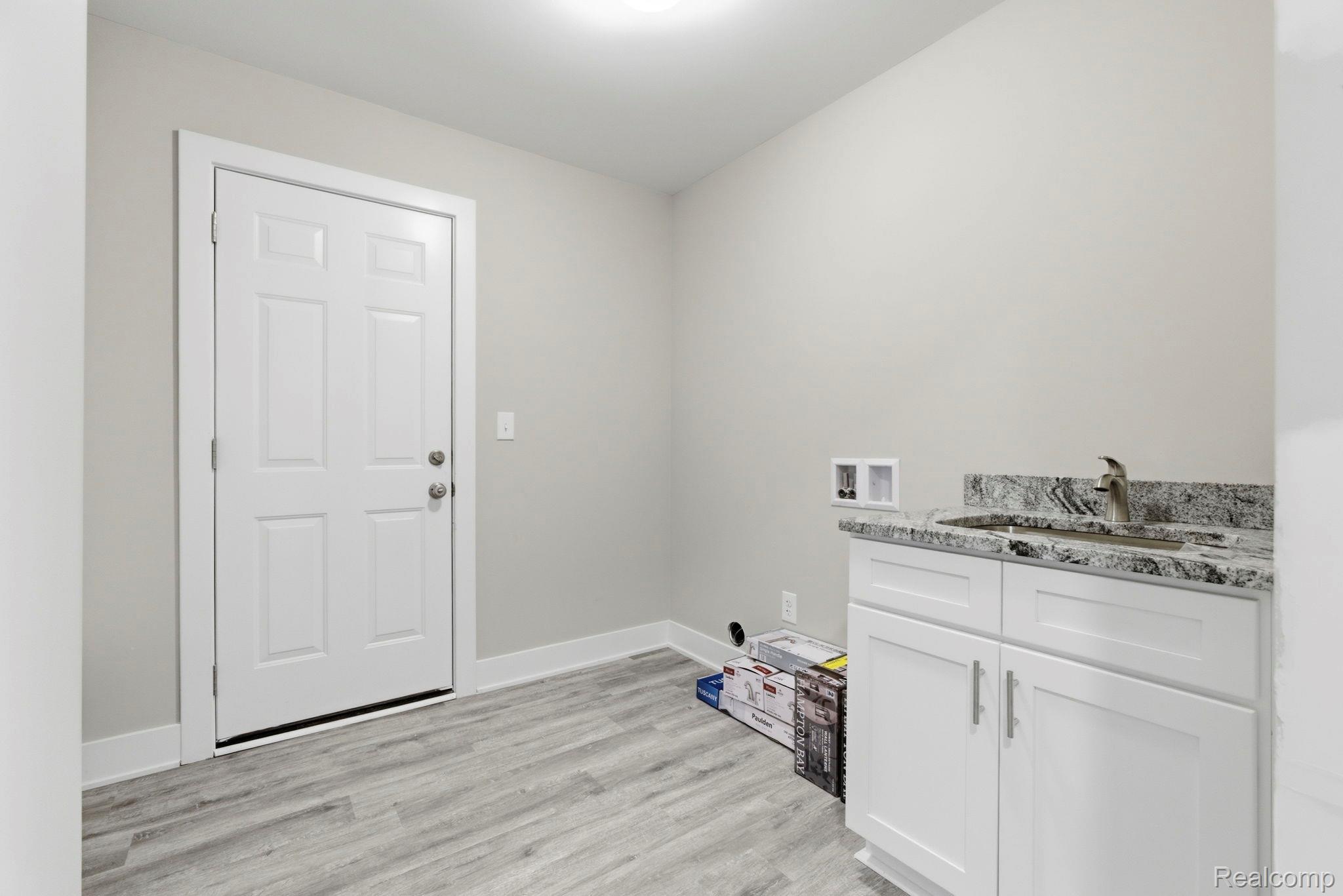 2281 Baltimore Davison, MI 48423 - Photo 19 of 26 Laundry room featuring light wood-style floors, cabinet space, and washer hookup