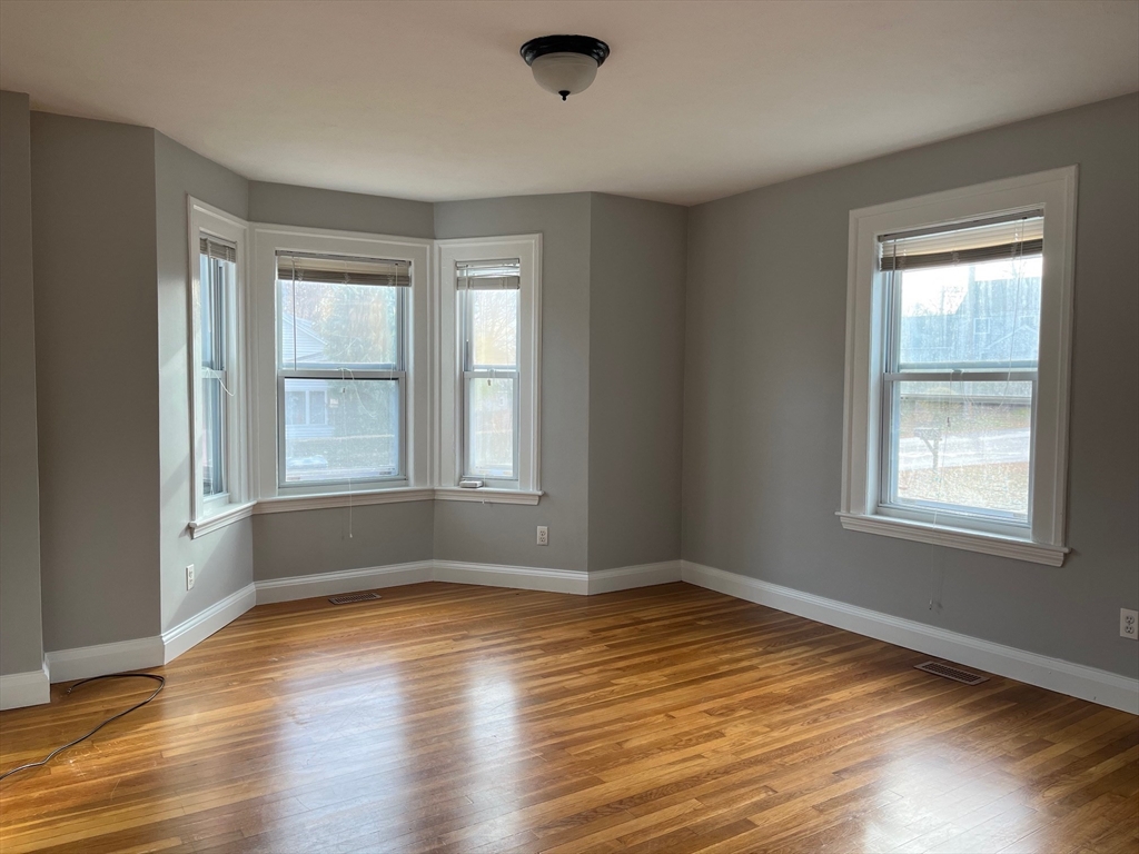 27 Pleasant Street, Unit 1 Middleton, MA 01949 - Photo 12 of 21 a view of an empty room with wooden floor and a window