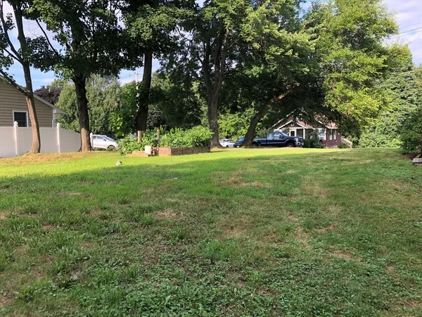 a view of a big yard with a house and large trees
