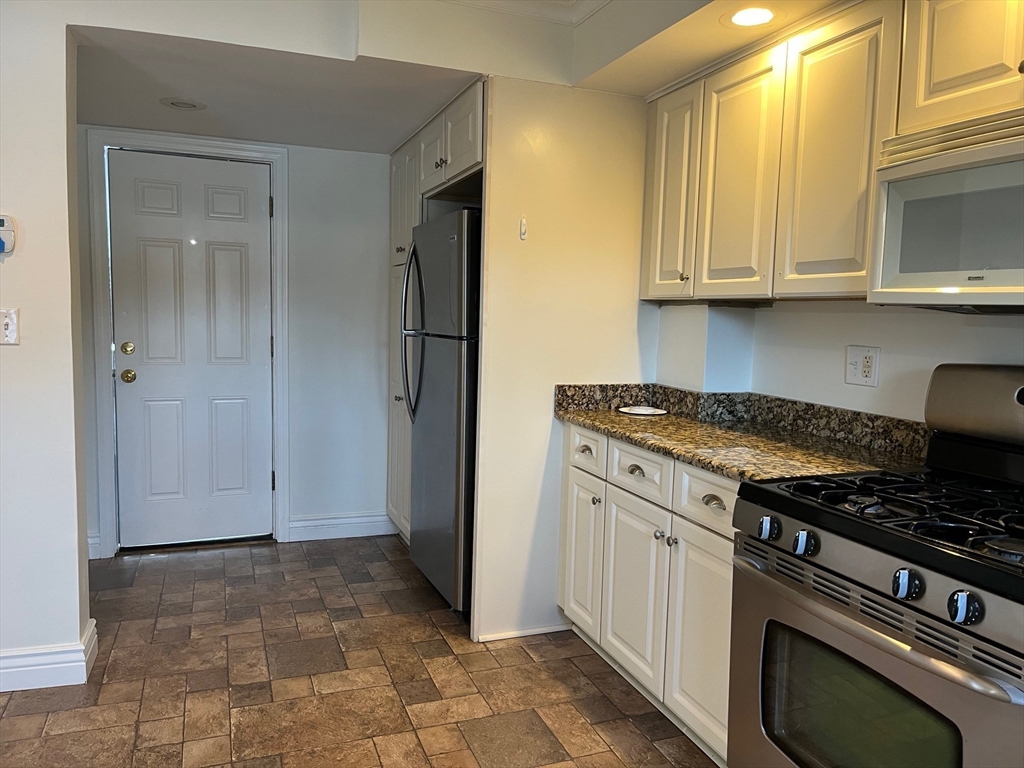 27 Pleasant Street, Unit 1 Middleton, MA 01949 - Photo 5 of 21 a kitchen with granite countertop a stove and a refrigerator